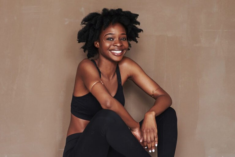 Front view. Young beautiful afro american woman in the studio against brown background.